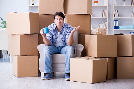 Young man moving in to new house with boxes